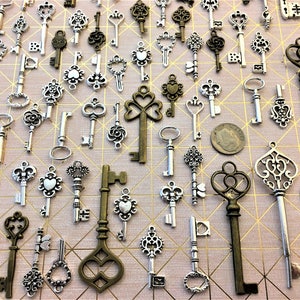 May include: A collection of antique-style skeleton keys in silver and bronze finishes. The keys are arranged on a pink background with a geometric pattern.