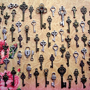 May include: A collection of antique-style keys in various shapes and sizes, with a mix of silver and bronze finishes. The keys are arranged on a brown background.