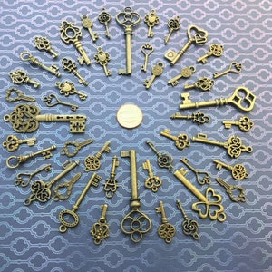 May include: A collection of antique-style skeleton keys in various shapes and sizes. The keys are made of metal and have a distressed, aged finish. They are arranged in a circular pattern on a blue background.