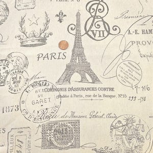 May include: Off-white fabric with a repeating pattern of Parisian stamps, the Eiffel Tower, crowns, and script. The word "PARIS" is prominently displayed. The design includes a variety of vintage-style elements in shades of gray.