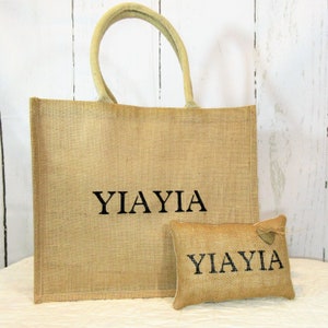 May include: A brown burlap tote bag and a smaller matching burlap pillow with the word "YIA YIA" embroidered in black on both items.