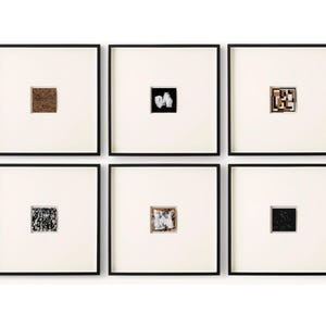 May include: A set of six square wall art pieces arranged in two rows of three. Each piece features a thin black frame, a wide off-white mat, and a small, centered square artwork displaying distinct abstract patterns in black, white, and brown tones.