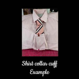 May include: A light pink dress shirt with a white collar and cuffs. A striped tie in pink, navy, and white is secured with a red clip. The text "Shirt collar cuff Example" is at the bottom.