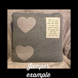 May include: A gray pillow with two heart-shaped patches made of a plaid fabric in blue, white, and tan. A rectangular patch with a poem is sewn on the pillow. The text "Jumper example" is at the bottom.