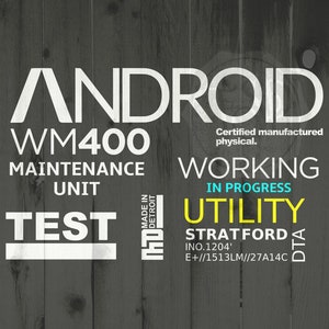 May include: A white sign with black text on a wood background. The sign reads "ANDROID WM400 MAINTENANCE UNIT TEST MADE IN DETROIT Certified manufactured physical. WORKING IN PROGRESS UTILITY STRATFORD INO.1204' E+//1513LM//27A14C DTA".