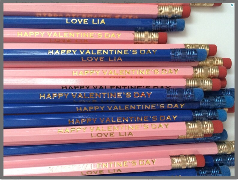 May include: A stack of pink and blue pencils with gold lettering that reads "Happy Valentine's Day" and "Love Lia".