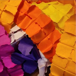 May include: A colorful paper garland with alternating colors of pink, purple, orange, yellow, and white. The garland is made of tissue paper and is perfect for a party or celebration.