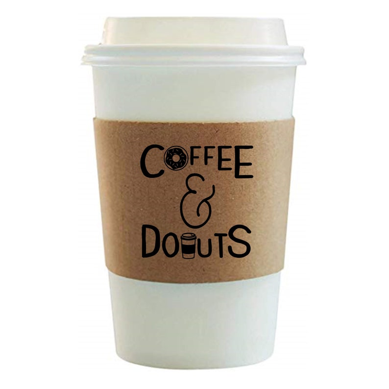 May include: White takeaway coffee cup with a brown paper sleeve that says "COFFEE & DONUTS" with a donut and coffee cup graphic.