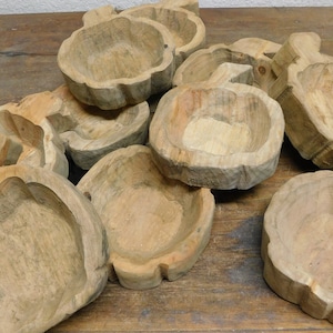 May include: A collection of rustic wooden bowls, each carved in a unique shape and featuring a natural wood grain. The bowls are perfect for serving snacks, dips, or salads.