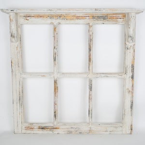 May include: White painted wood window frame with six panes. The frame has a distressed look with visible wood grain and a slightly weathered appearance.