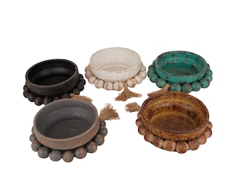 May include: Five decorative bowls with beaded trim and tassels. The bowls are in various colors, including black, white, turquoise, and brown.