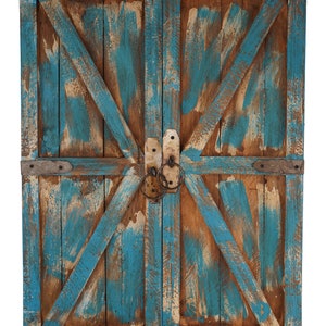 May include: A pair of weathered wooden doors with a blue paint finish. The doors have a rustic, farmhouse style with a diagonal wood plank design and metal hardware.