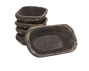 May include: A set of four rustic wooden bowls, with a dark brown finish. The bowls are stacked on top of each other, with the largest bowl on the bottom and the smallest bowl on top. The bowls are made of natural wood and have a slightly uneven surface.