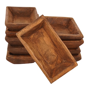 May include: A stack of rectangular wooden bowls with a rustic, weathered appearance. The bowls are a warm brown color and have a square shape with slightly sloped sides. The wood grain is visible.