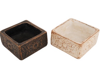 May include: Two square ceramic decorative bowls with floral designs. One bowl is brown and the other is white.