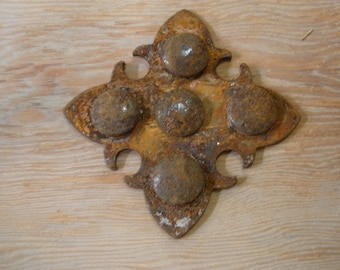 May include: A rusty metal decorative piece in the shape of a four-pointed star with five round metal accents. The piece has a distressed, aged look.