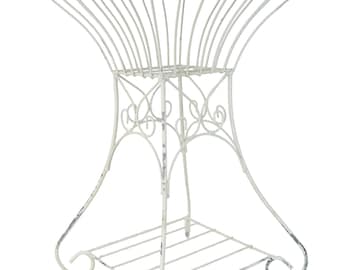 May include: Off-white, wrought iron plant stand with a decorative, openwork design. The stand features a square base with a slatted shelf and curved legs. The top has a basket-like shape with decorative swirls.