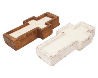May include: Two wooden cross-shaped candle holders, one in natural wood and one painted white. Both have a recessed area for a candle and a cross design.