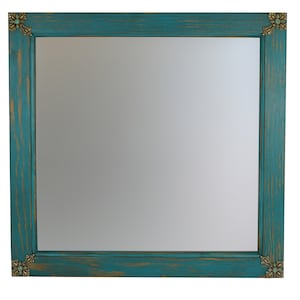May include: A teal blue wood framed mirror with ornate gold corner accents. The mirror has a distressed finish and a simple rectangular shape.