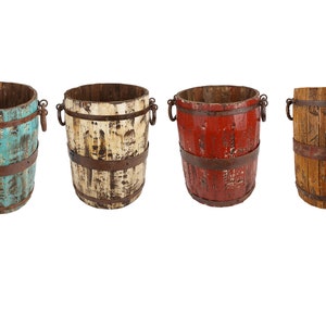 May include: Four wooden buckets with metal hoops and handles. The buckets are painted in different colors: turquoise, white, red, and natural wood.