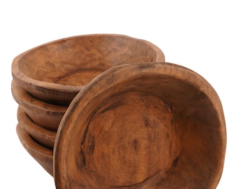 May include: A set of four wooden bowls, stacked on top of each other. The bowls are made of a dark brown wood and have a natural, rustic finish.