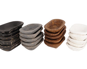 May include: A set of 40 small wooden bowls stacked in four piles. The bowls are in four colors: black, gray, brown, and white.