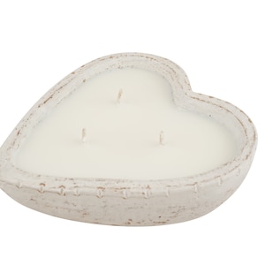 May include: White heart-shaped candle with three wicks in a white ceramic holder.