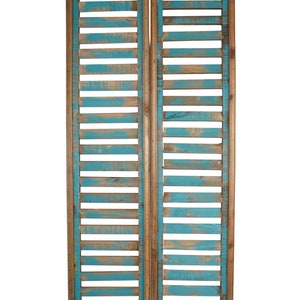 May include: Two wooden panels with a blue painted finish and a slatted design. The panels are joined together to create a decorative room divider.
