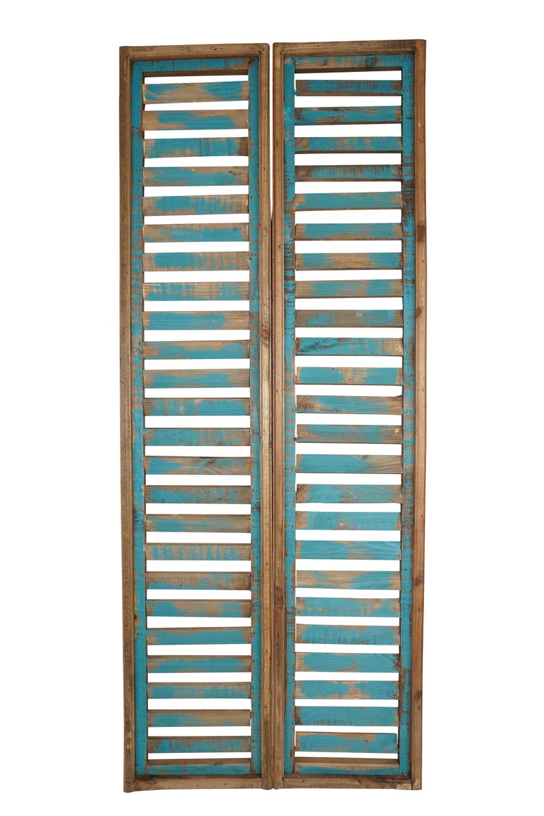 May include: Two wooden panels with a blue painted finish and a slatted design. The panels are joined together to create a decorative room divider.