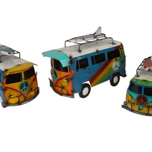 May include: Three colorful metal toy vans with peace signs painted on the front. Each van has a surfboard on top and is painted in a rainbow pattern with blue, yellow, orange, and green.