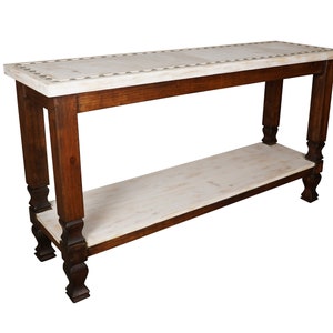 May include: A whitewashed wood console table with a lower shelf. The table has a distressed finish and features turned legs.