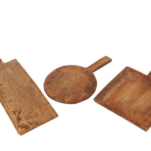 May include: Three wooden cutting boards with handles. The boards are different shapes and sizes. One is rectangular, one is round, and one is square.