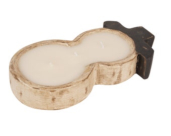 May include: A snowman-shaped candle holder made of wood with a white and black paint finish. The holder has two wells for candles and is filled with white wax.
