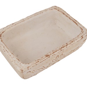Pu&ograve; includere: Un piatto rettangolare in ceramica bianca con un design decorativo attorno al bordo. Il piatto ha un aspetto rustico e usurato.