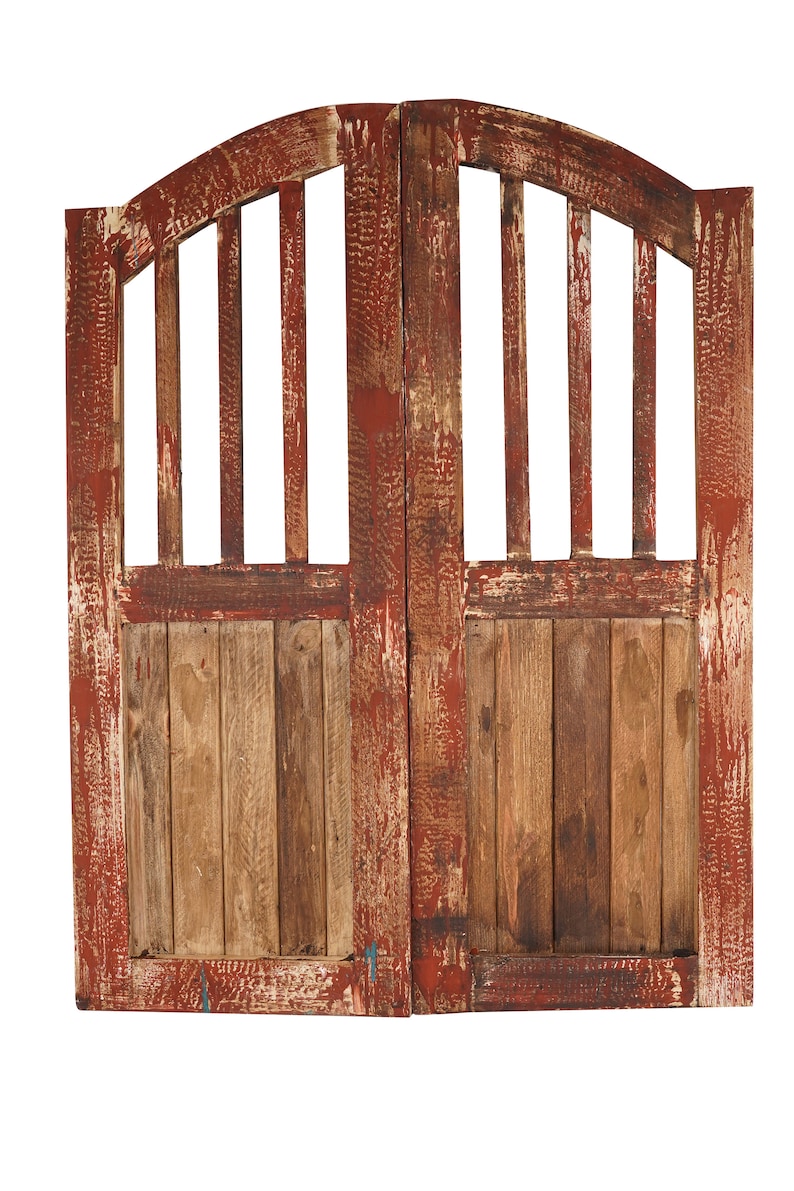 May include: A pair of weathered wooden doors with a red paint finish. The doors have a curved top and a slatted design. The wood is a natural brown colour with areas of red paint showing through.