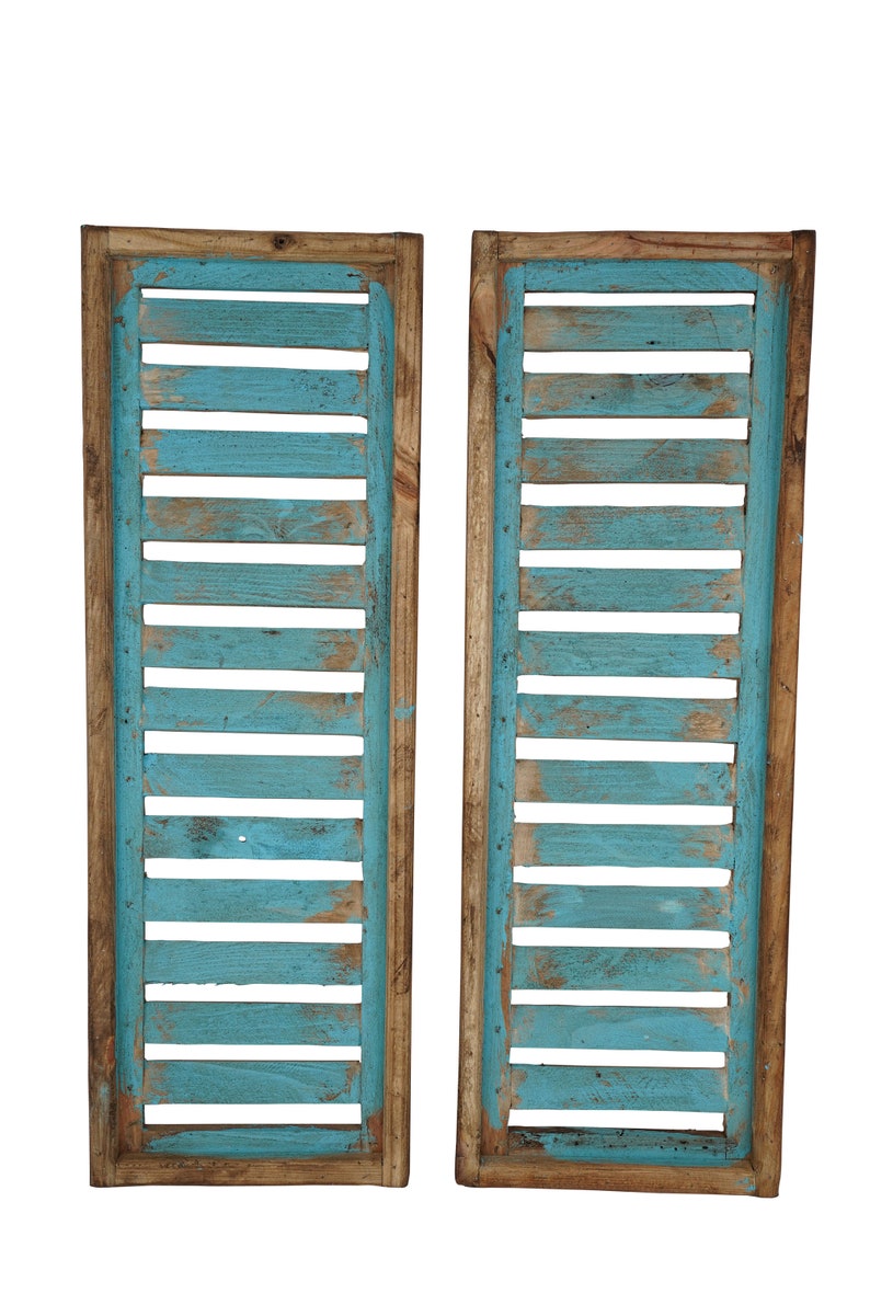 May include: Two wooden shutters painted in a light blue color. The shutters are made of thin wooden slats and have a rustic, weathered look.