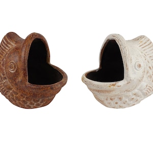 May include: Two ceramic fish planters, one brown and one white, with open mouths and a textured surface. The planters are shaped like fish with detailed scales and eyes.