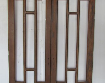 Puede incluir: Un par de puertas de madera antiguas con un diseño de panel de vidrio geométrico. Las puertas son marrones y tienen un acabado desgastado.