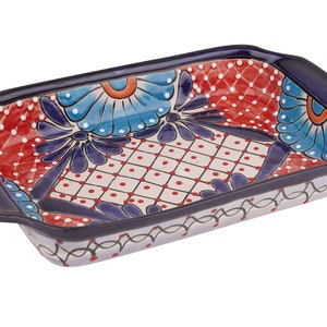 May include: A rectangular ceramic baking dish with blue, red, and white floral designs. The dish has two handles on the sides.