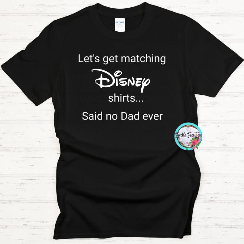May include: Black t-shirt with white text that reads "Let's get matching Disney shirts... Said no Dad ever".