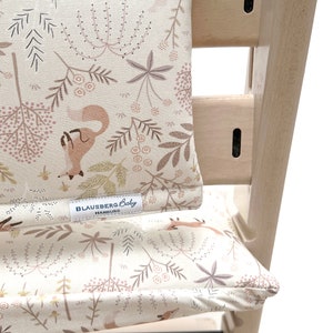 Ein weißer Tripp Trapp Hochstuhl von Stokke mit einem cremefarbenen und rosafarbenen Kissen mit einem Fuchs-Design von Blausberg Baby. Das Kissen für den Stokke Tripp Trapp Hochstuhl trägt den Schriftzug "Blausberg Baby Hamburg" und ist für Kinder gemacht, die selbständig sitzen können und ken Baby Set mehr benötigen. Ideal für Kinder ab 3 Jahre