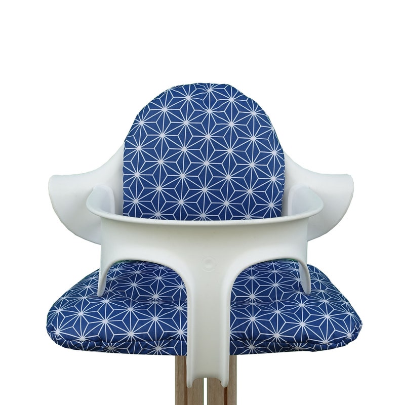 May include: White high chair with a blue and white geometric pattern cushion.