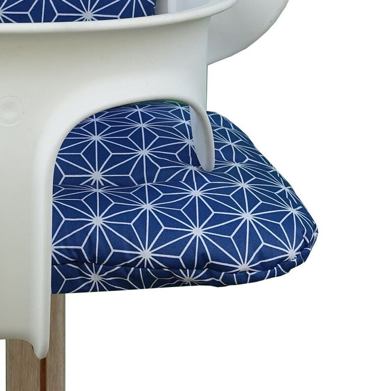 May include: A blue and white geometric patterned chair cushion. The cushion is made of fabric and has a white geometric pattern on a blue background.