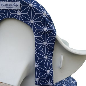 May include: A blue and white geometric patterned high chair cover with the text "Blausberg Baby Hamburg" on the top.