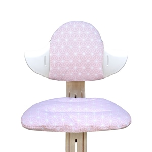 May include: A pink and white patterned chair with a rounded back and a cushioned seat. The chair is made of wood and has a white frame.