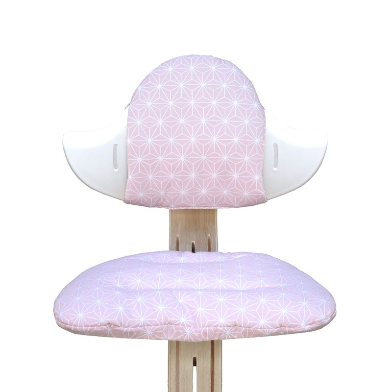 May include: A pink and white patterned chair with a rounded back and a cushioned seat. The chair is made of wood and has a white frame.