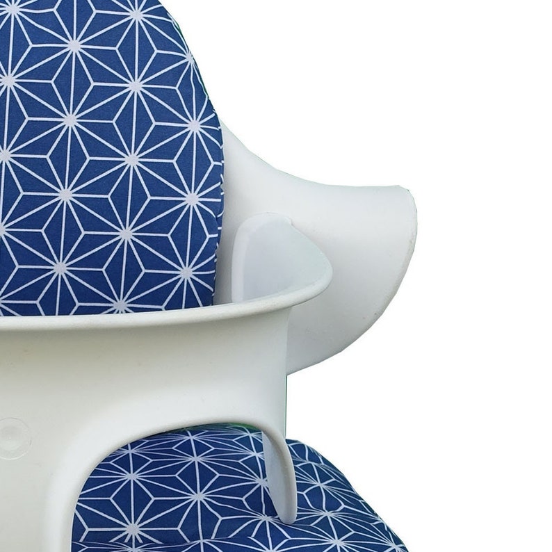 May include: White high chair with a blue and white geometric patterned seat cushion.