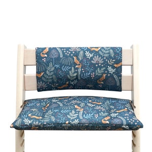 May include: A blue and white patterned chair cushion with a fox design. The cushion is made of fabric and has a padded seat and back.