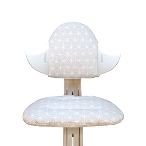 May include: A white and beige chair with a geometric pattern on the seat and back cushions. The chair is made of wood and has a unique design.