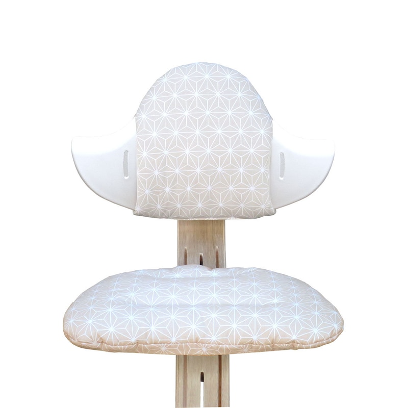May include: A white and beige chair with a geometric pattern on the seat and back cushions. The chair is made of wood and has a unique design.